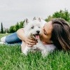 Frau mit Hund auf einer Wiese