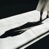 Eine Frau geht vor ihrem Schatten weg