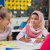 Kinder können am leichtesten Vorurteile abbauen, wie man am Beispiel dieses jungen arabischen Mädchens mit Hidschab bei einer Übung mit ihrer besten Freundin in der Schule sieht.