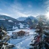 Ein Hotel inmitten einer verschneiten Berglandschaft. Hier kannst du natürlich auch wandern, Winter ist hier gleichbedeutend mit kalter Sommer.   