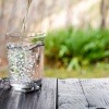 Lebendig wirkendes Wasser fließt in ein Glas