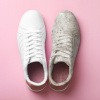 Ein sauberer weißer Sneaker und ein schmutziger Sneaker