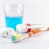 Utensilien zum Zähne putzen wie Zahnbürste, Zahnpasta und Zahnseide liegen nebeneinander