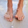 Füße im Wasser mit Zehen ohne Nagelpilz