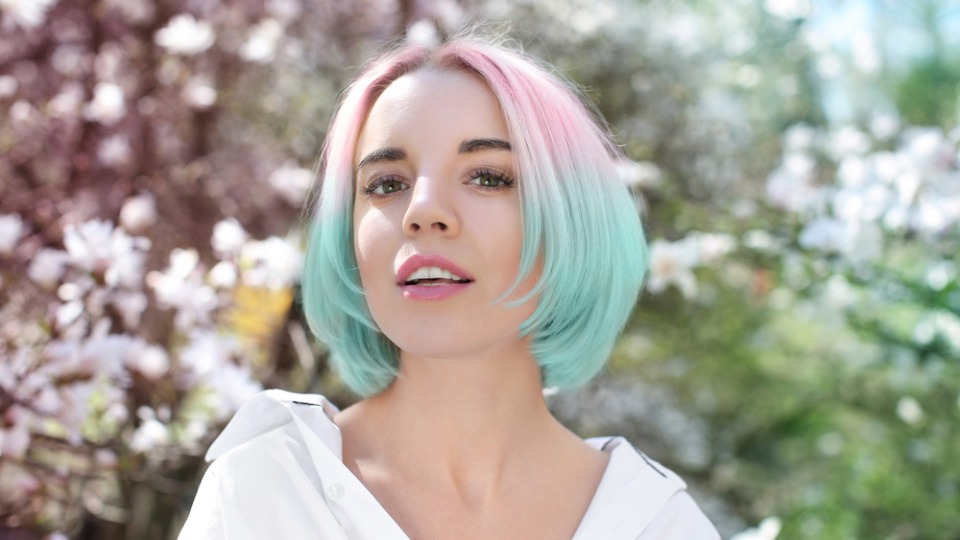 Kurze Haare in Kombi mit Pastellfarben sehen Spitze aus Eine Frau mit blonden Haaren und pastellblauen Spitzen