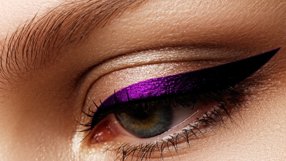 Der Eyeliner darf gerne farbig ausfallen! Eine Frau trägt eine Eyeliner in lila
