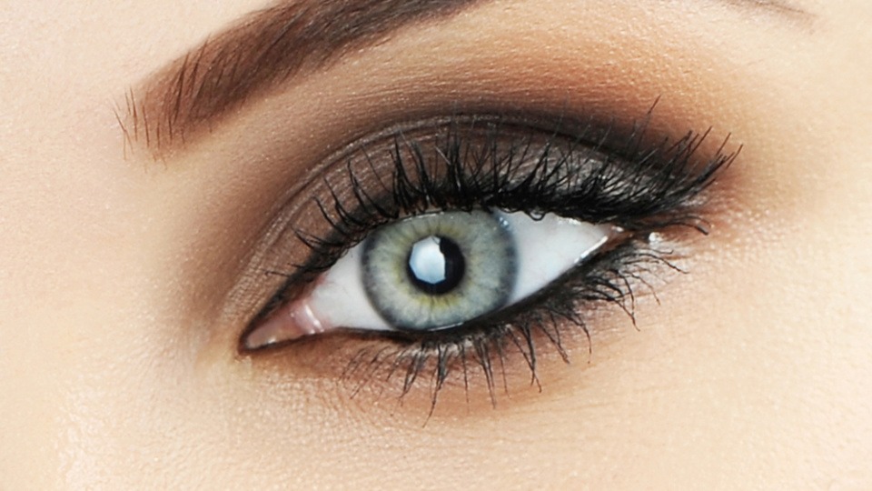 Eine Frau mit grauen Augen ist mit dem passenden Make-up geschminkt Eine Frau mit grauen Augen ist mit dem passenden Make-up geschminkt