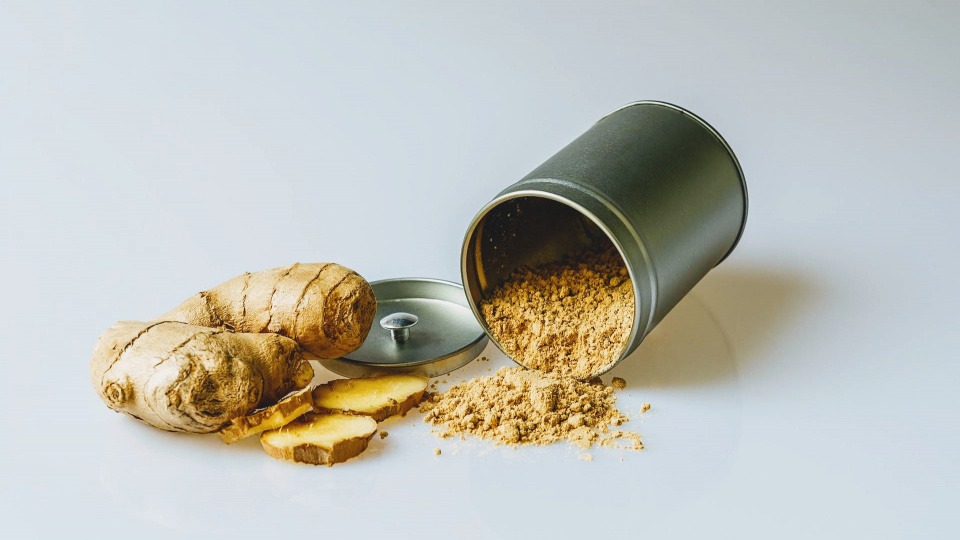 Ingwer wird gerne in der ayurvedischen Ernährung verwendet Getrockneter Ingwer ist neben einer Dose mit Pulver