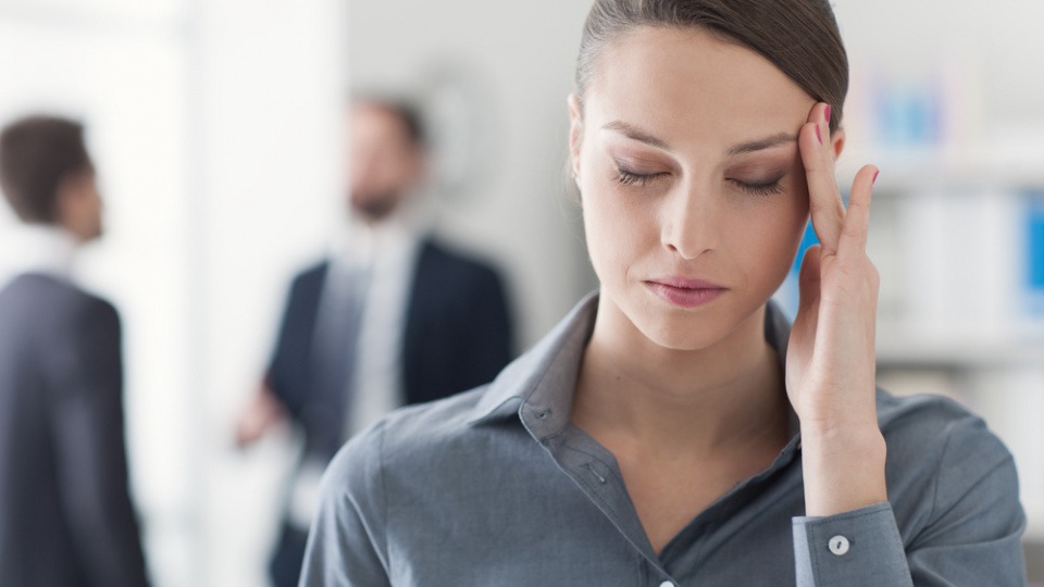 Bei schwachen Kopfschmerzen hilft Pfefferminzöl besonders gut Eine Frau hat Kopfschmerzen