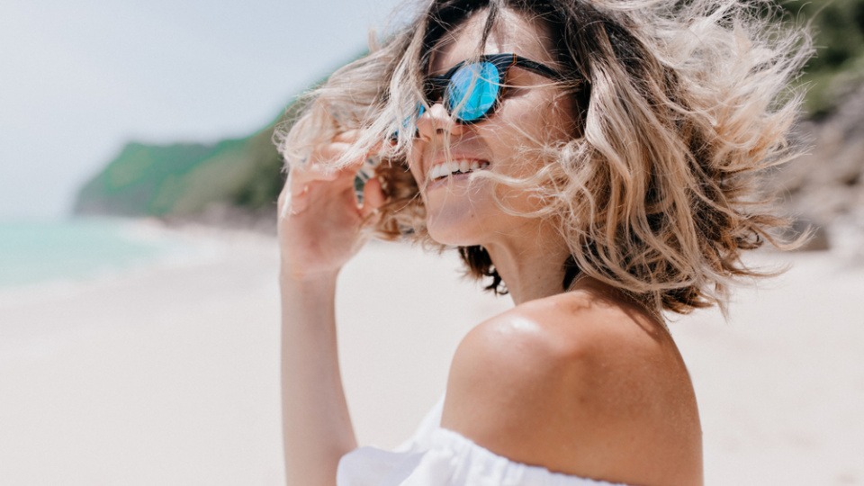Kurze Haare sind im Sommer besonders beliebt und gefragt Eine Frau mit kurzen Haaren und Sonnenbrille