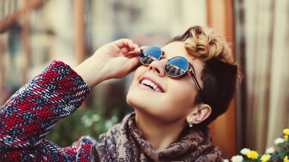 Auch jungenhafte Frisuren liegen klar im Trend! Eine Frau mit lockigen kurzen Haaren