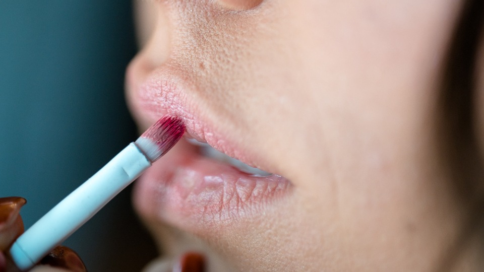 Iris Hagen stimmt ihren Make-up-Workshop in Linz auf deine individuellen Bedürfnisse ab. Eine Frau trägt einen Lippenstift auf