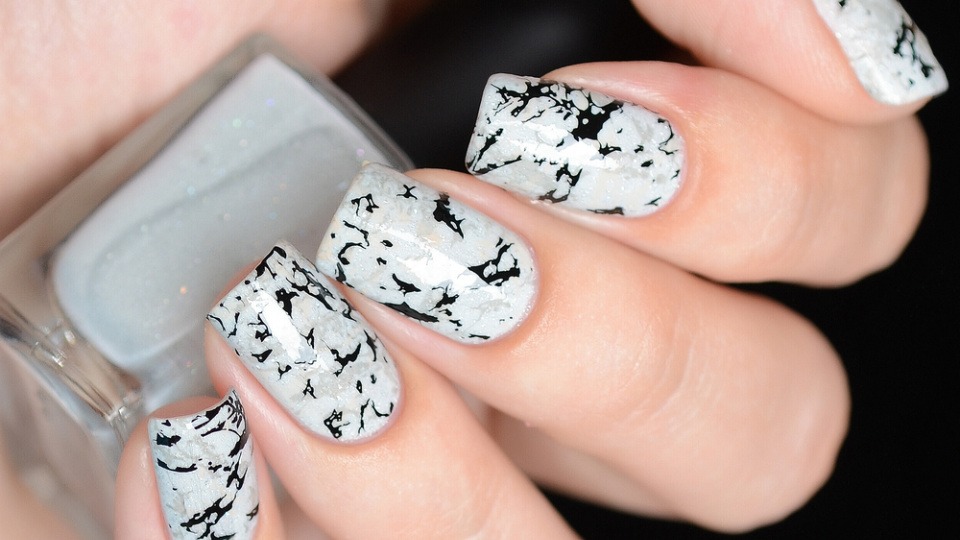 Fingernägel sind mit Gelnägeln mit schwarz-weißem Muster lackiert Fingernägel sind mit Gelnägeln mit schwarz-weißem Muster lackiert