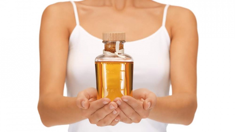 Öle können unserem Wohlbefinden sehr gut tun Eine Frau hält Öle als Medizin in einer Flasche