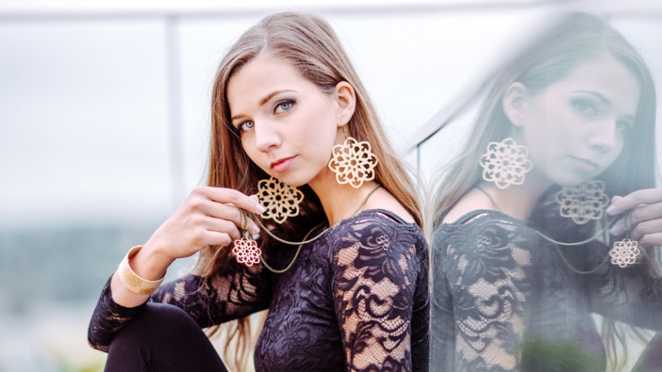 Eine Frau trägt Ohrringe und eine Kette aus Holz