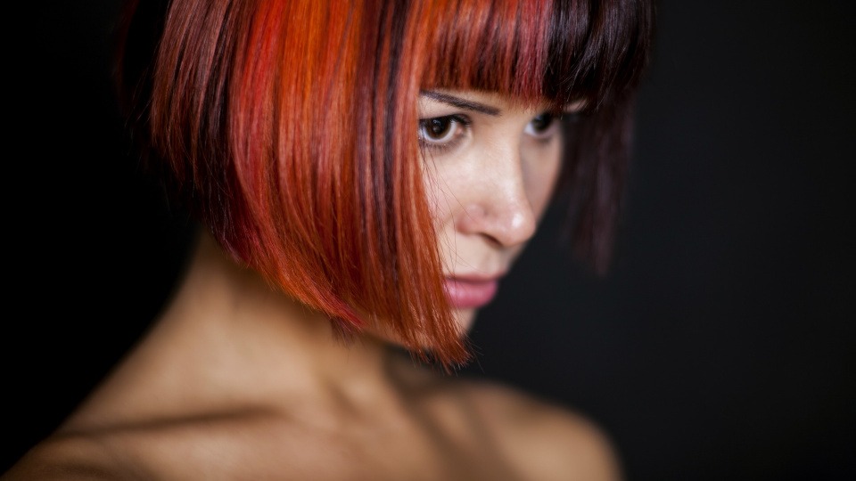 Frauen mit roten Haaren strahlen Selbstbewusstsein aus Eine Frau hat rote Haare und Strähnen