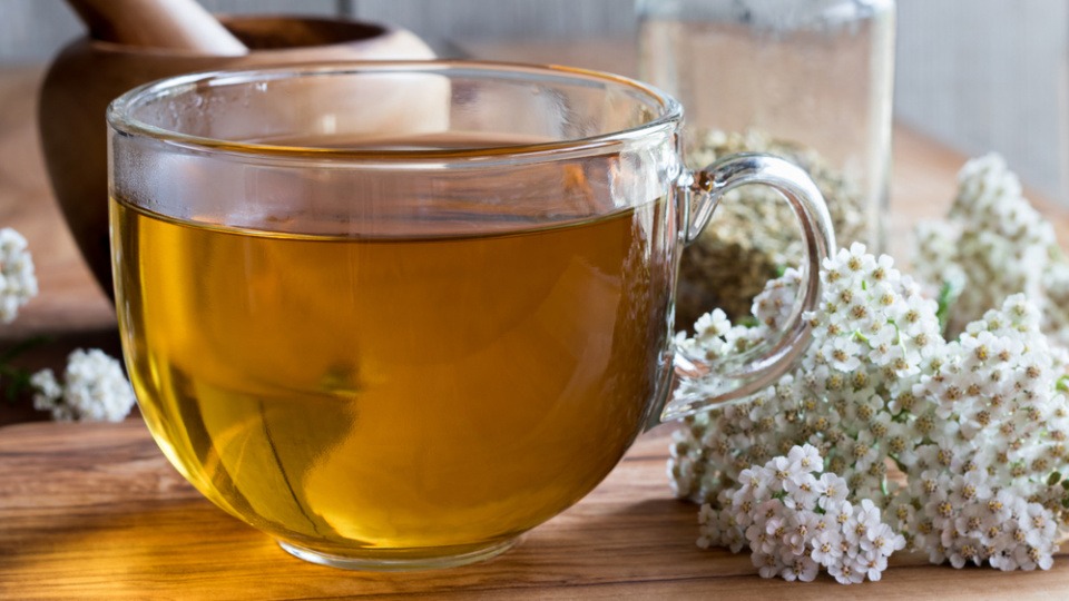 Schafgarbe kann bei Problemen, die bei PMS auftreten, hilfreich sein. Schafgarbe neben einer Tasse Tee