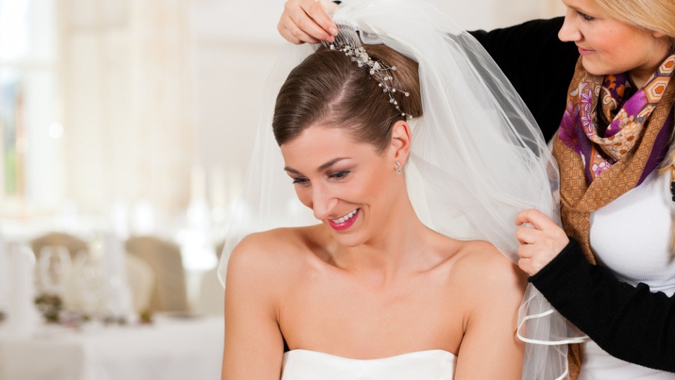 Frisuren hängen meist vom Schleier ab Einer Braut wird der Schleier angesteckt