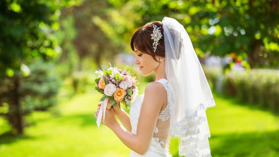 Schleier können sowohl oberhalb als auch unterhalb des Haares angebracht werden Eine Braut mit Schleier über dem Haar