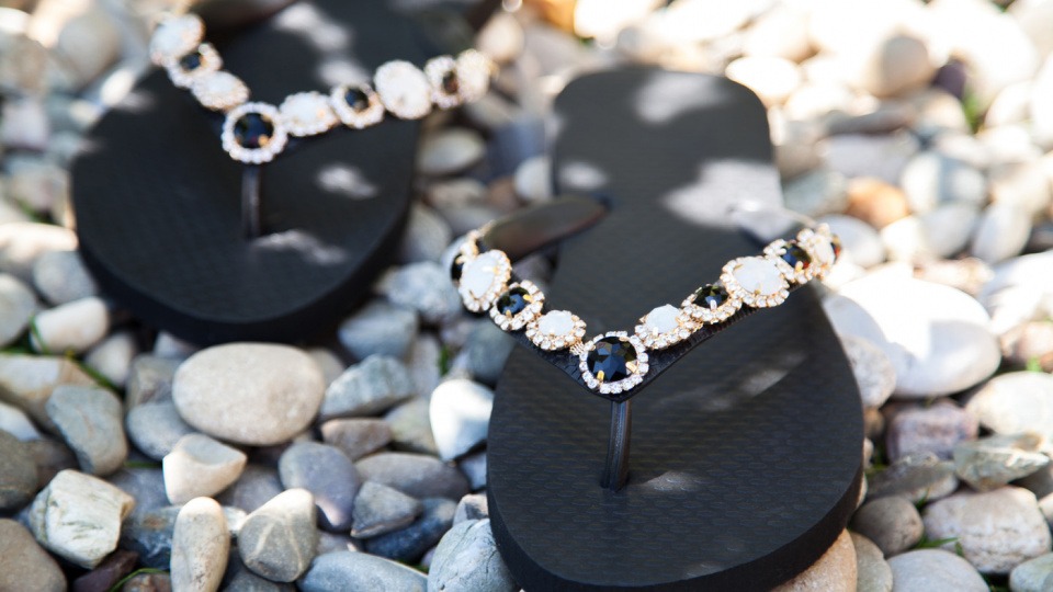 Die einzigartigen Zehensandalen sind überall ein Hingucker. schwarze Zehensandalen auf kleinen Steinen