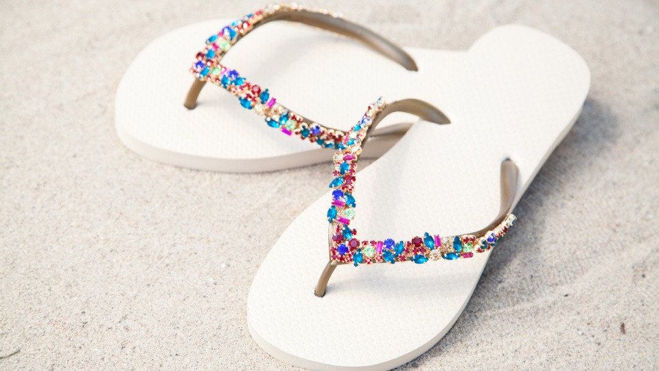 Die einzigartigen Zehensandalen sind überall ein Hingucker. weiße Zehensandalen auf heller Oberfläche