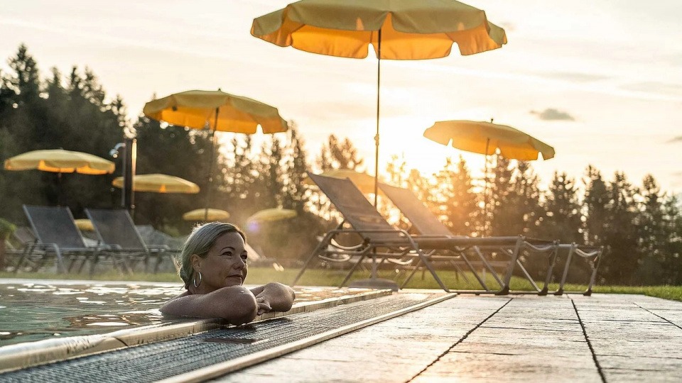 Auch zum Baden ist ein Sommer in den Bergen hervorragend geeignet Frau badet im Pool im Sommer in den Bergen