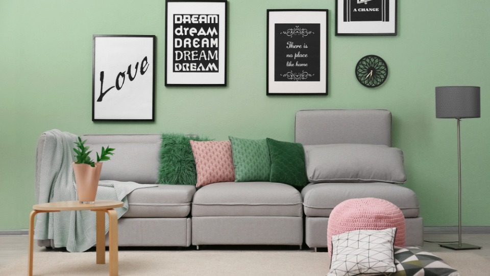 Ein Wohnzimmer hat eine grüne Wandfarbe und viele Bilder Ein Wohnzimmer hat eine grüne Wandfarbe und viele Bilder