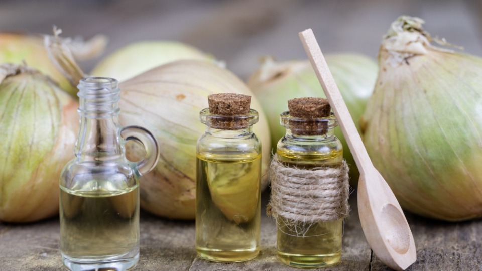 Eine Haarkur aus Zwiebelsaft bewirkt Wunder Verschiedene Flüssigkeiten in kleinen Glasflaschen