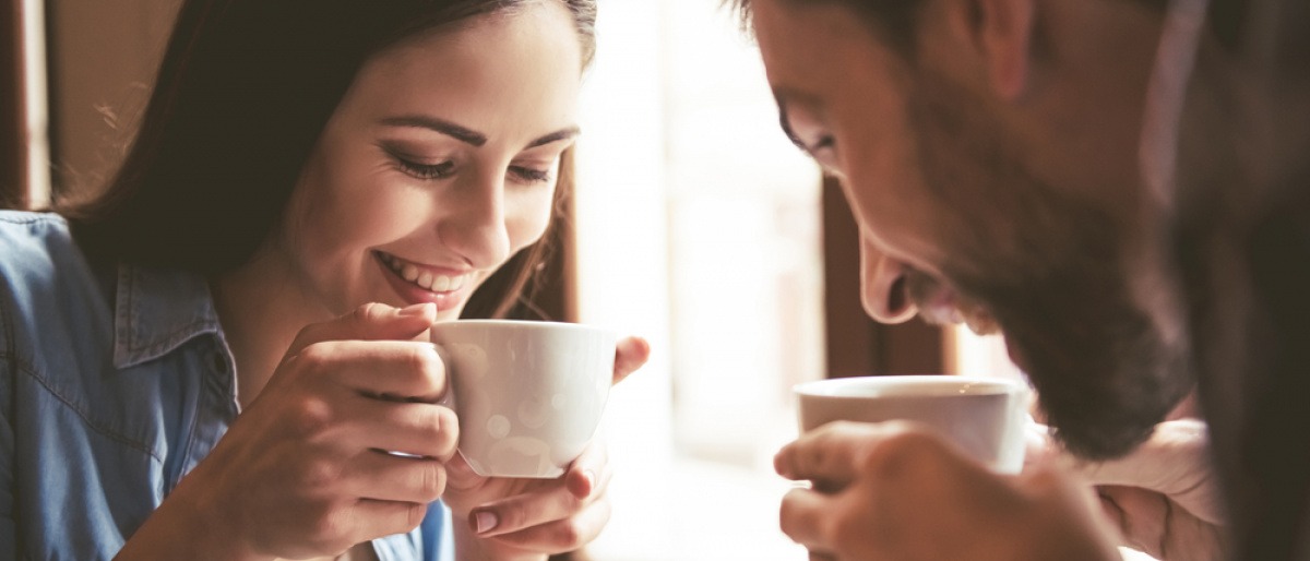 Mann und Frau beim Kaffeetrinken wirken glücklich