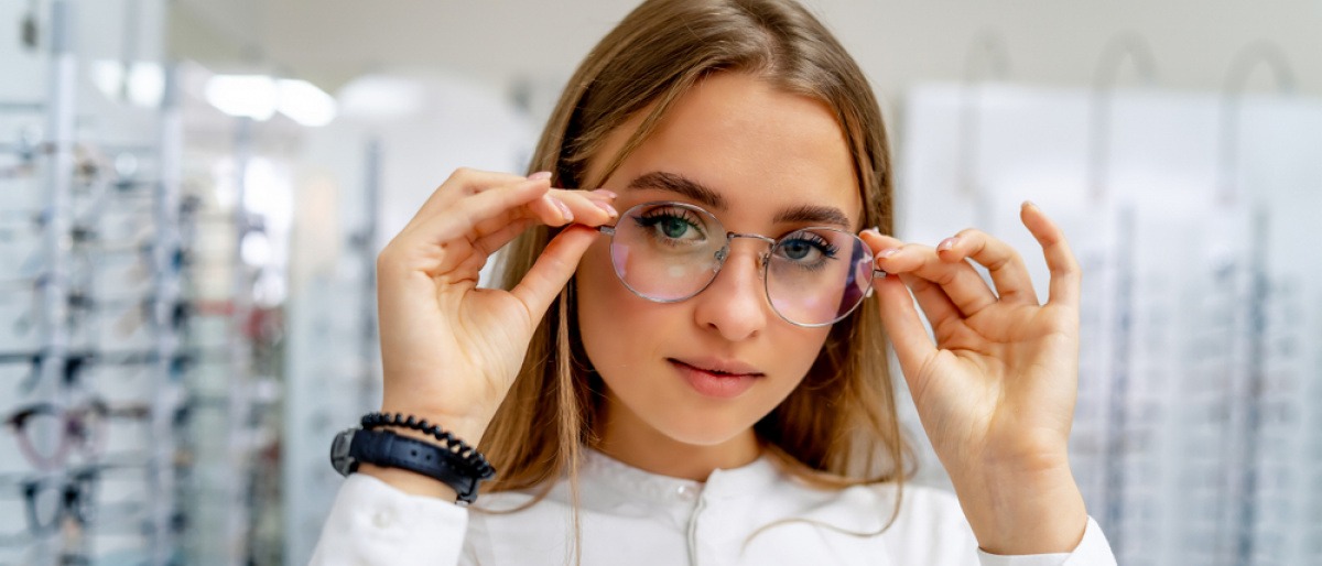 Frau setzt runde Brille als Brillentrend 2023 auf