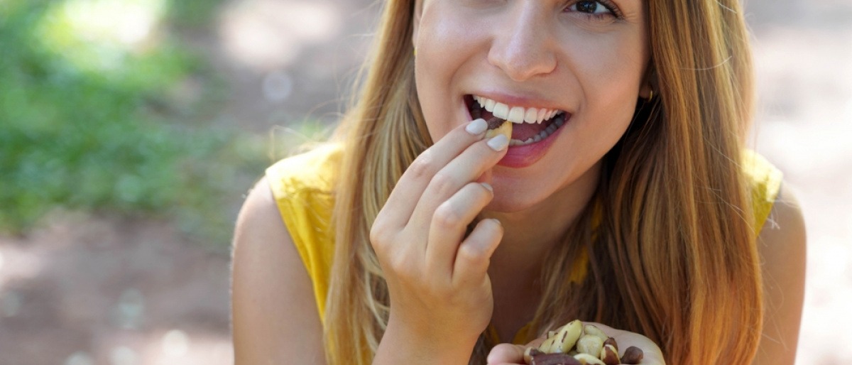 Frau isst Nüsse als Snack