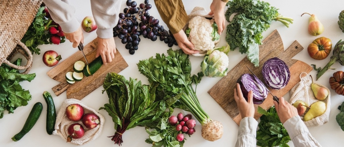 Menschen schneiden herbstliches Gemüse für das Essen