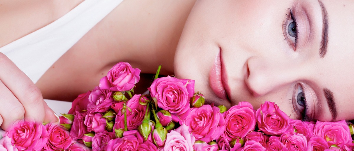 schöne Frau liegt auf Rosenblüten
