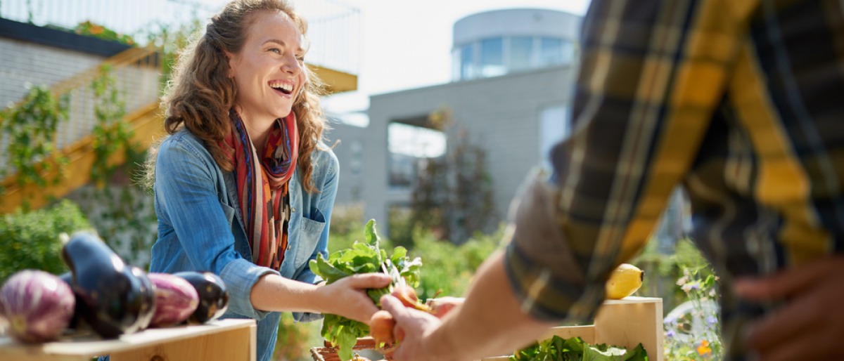 Frau kauft am Markt regionales Gemüse als Ernährungstrend 2024