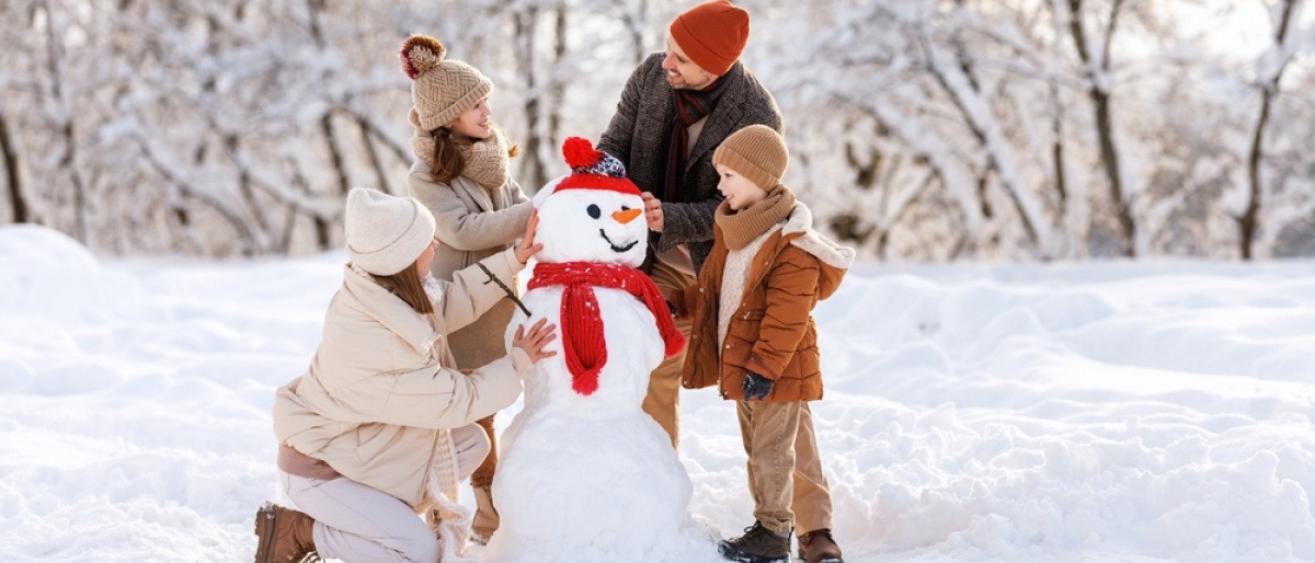 Familie baut bei Neumond im Dezember einen Schneemann