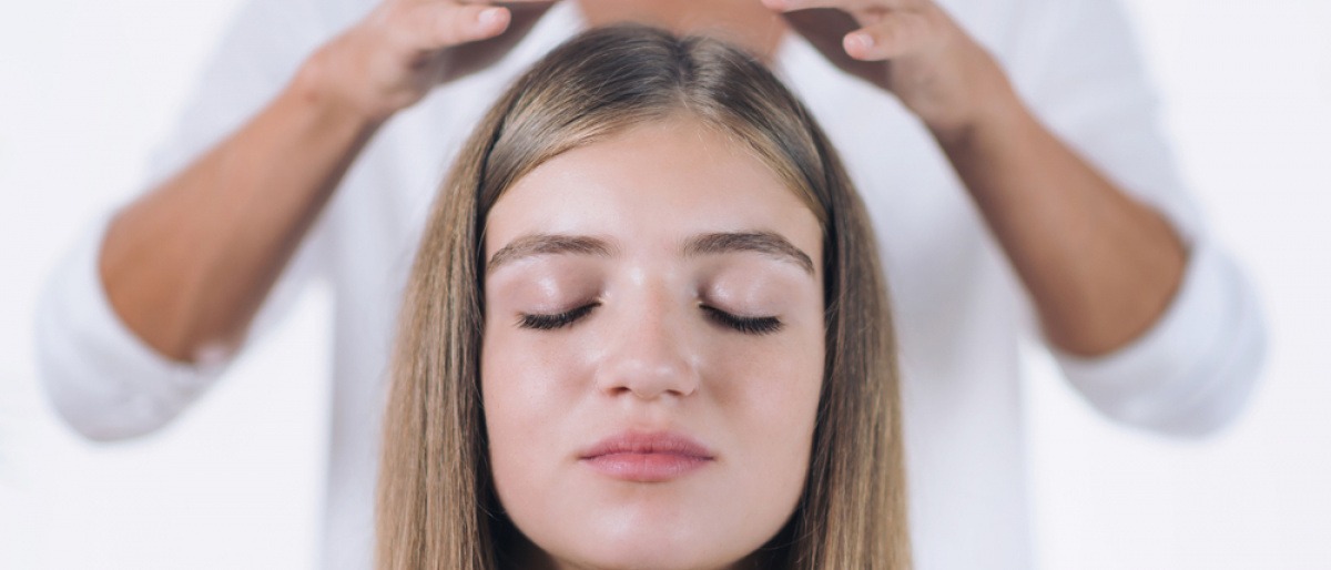 Reiki-Behandlung bei einer Frau zur Aktivierung des Kronenchakras