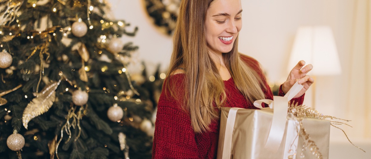 Frau packt zufrieden ein Geschenk aus