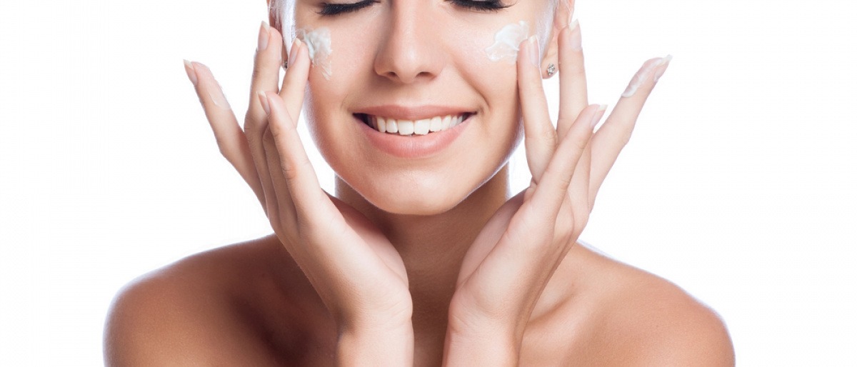 Eine Frau cremt ihr Gesicht ein und nimmt Kollagen Kosmetik Produkte