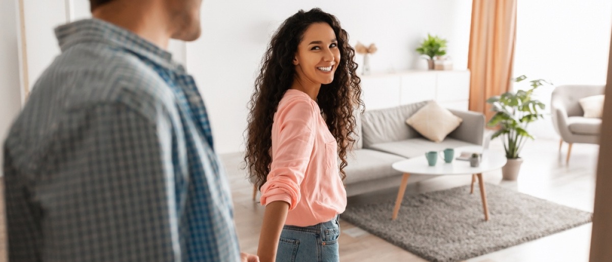 Eine Frau geleitet einen Mann in eine Wohnung, sich fragend wann ist eine Beziehung eine Beziehung?