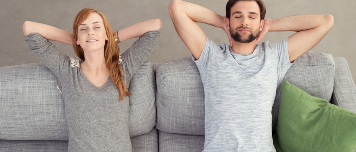 Ein Mann und eine Frau liegen glücklich auf gepolsterten Möbeln, die die Akustik verbessern
