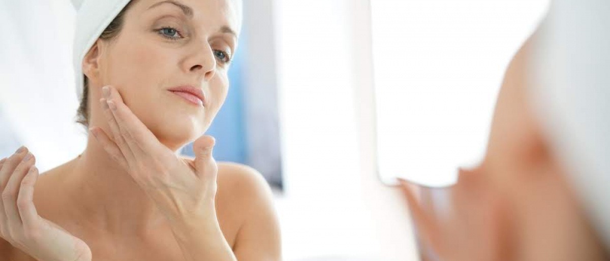 Eine Frau gibt Anti-Aging Öl in ihr Gesicht