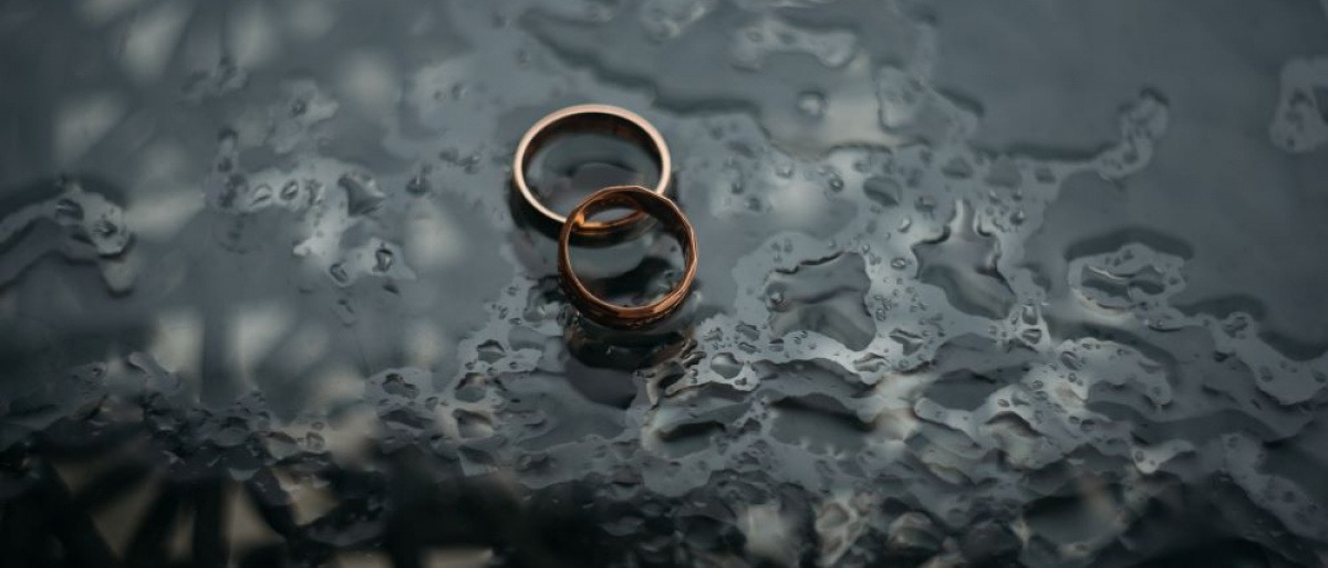 Zwei Eheringe im Regen als Zeichen für Auszeit von der Ehe