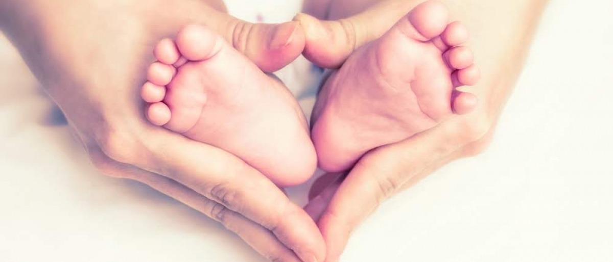 Hände umfassen Babyfüße