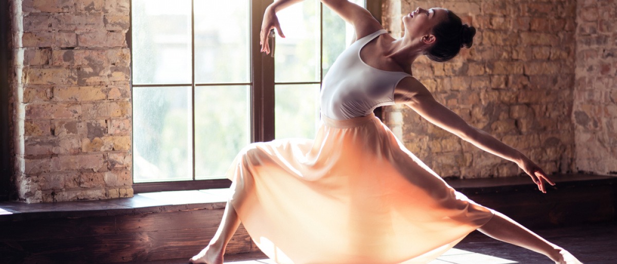 Eine Ballerina in Pose vor einem Fenster