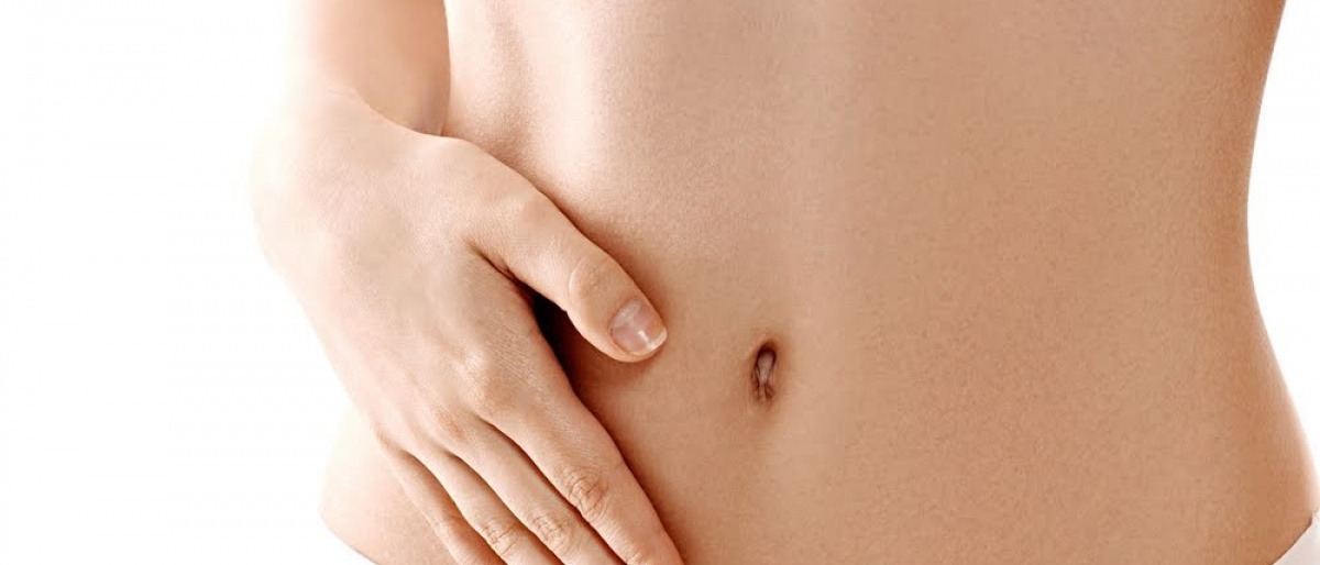 Eine Hand liegt auf einem flachen Bauch