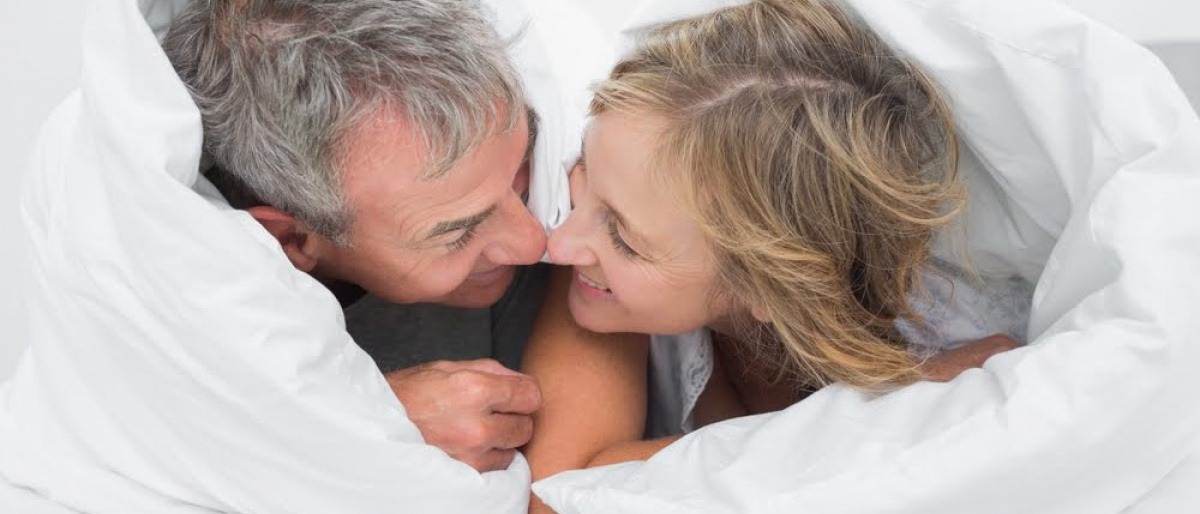 Ein Mann und eine Frau in den Wechseljahren im Bett