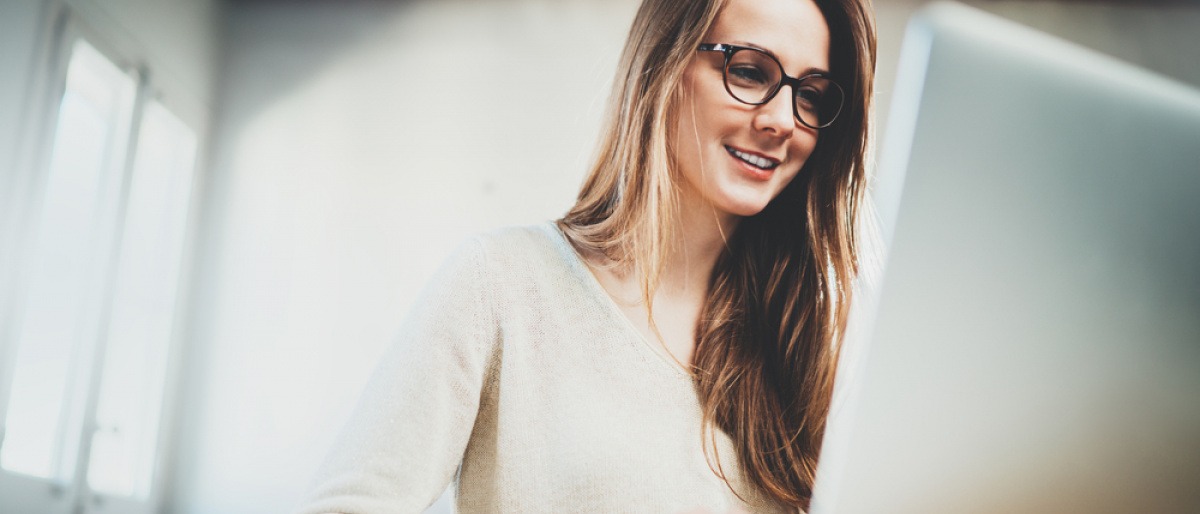 Eine Frau hat bei der Bildschirmarbeit eine Brille auf