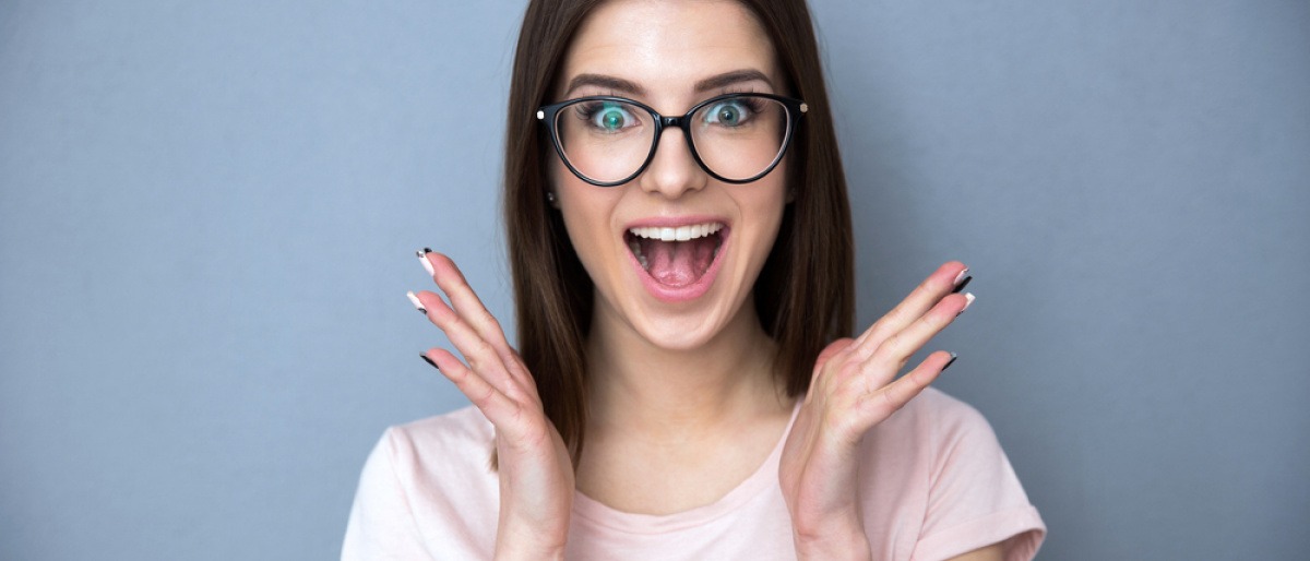Brille reinigen Ultraschallbad - junge Frau ist glücklich über ihre sauberen und glänzenden Brillengläser nach einem Ultraschallbad.
