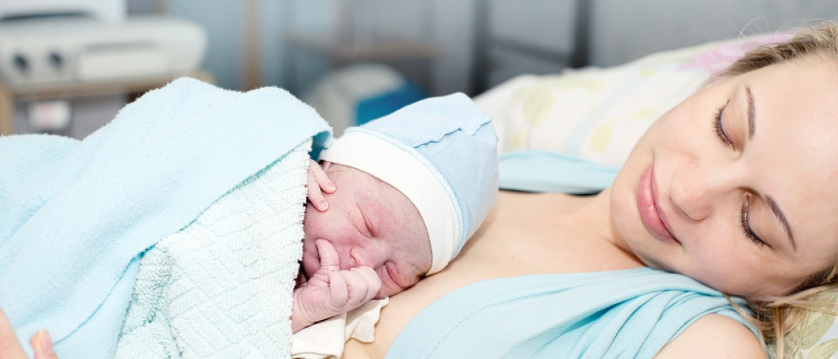 Ein Baby liegt bei einer Frau auf der Brust nach Schwangerschaft