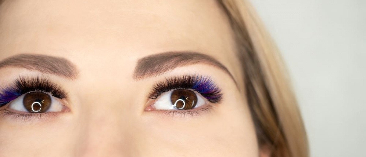 Eine Frau trägt künstliche Wimpern mit bläulichem Farbverlauf